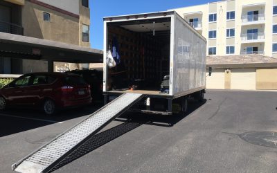 Lkw mit geöffneter Ladefläche und Rampe.